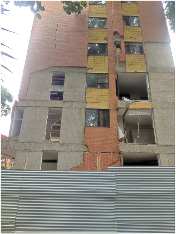 Edificio en Cali con cinta de peligro no pase y fachaleta de ladrillo caída en la acera tras el sismo de agosto 2026
